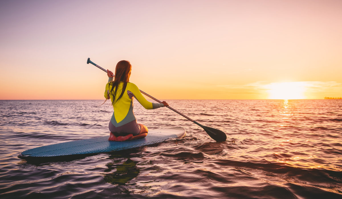 Femme en combi faisant du paddle